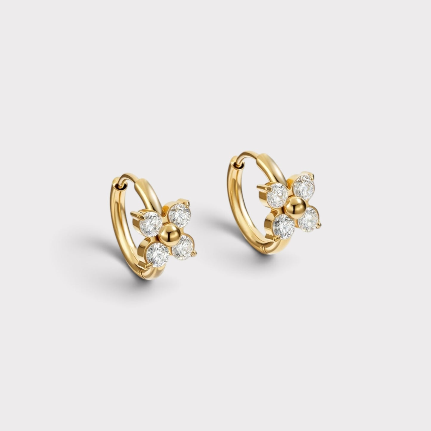 Brincos de argola Verve em tom dourado com detalhe de flor central adornado com zircónias brilhantes.
