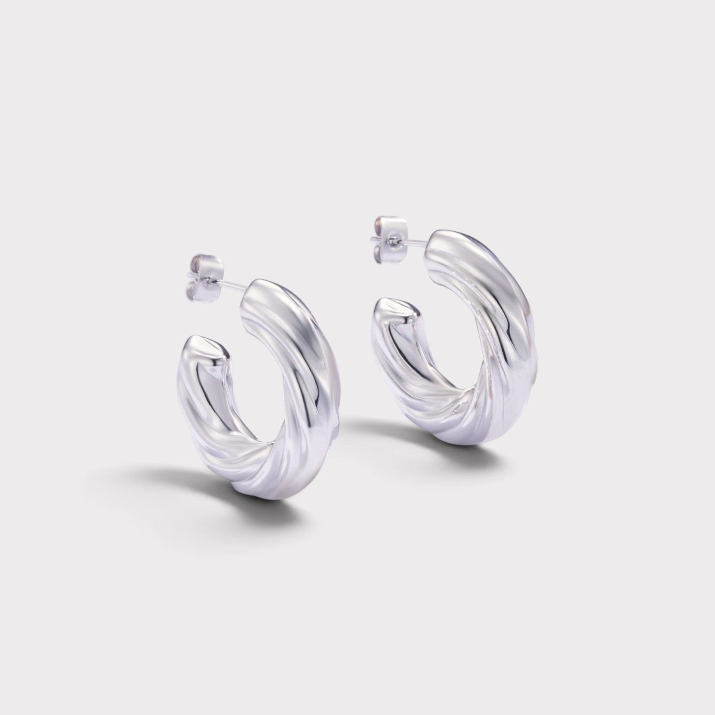 Brincos de argola Verve em prata com design espiral torcido e acabamento polido para um visual moderno e elegante.