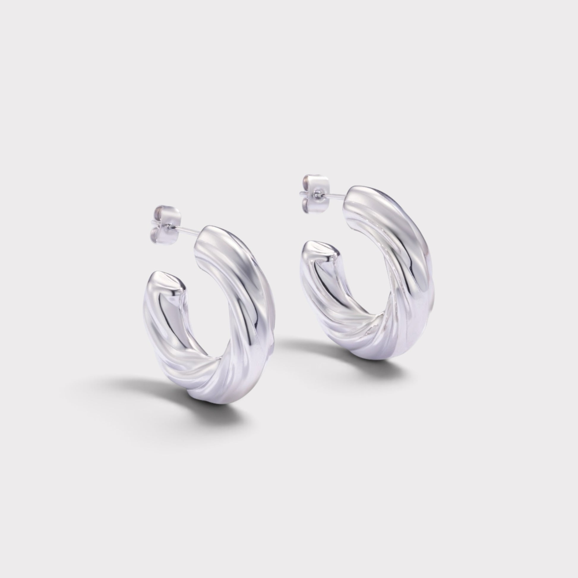 Brincos de argola Verve em prata com design espiral torcido e acabamento polido para um visual moderno e elegante.