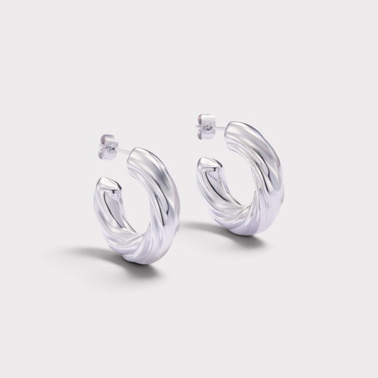 Brincos de argola Verve em prata com design espiral torcido e acabamento polido para um visual moderno e elegante.