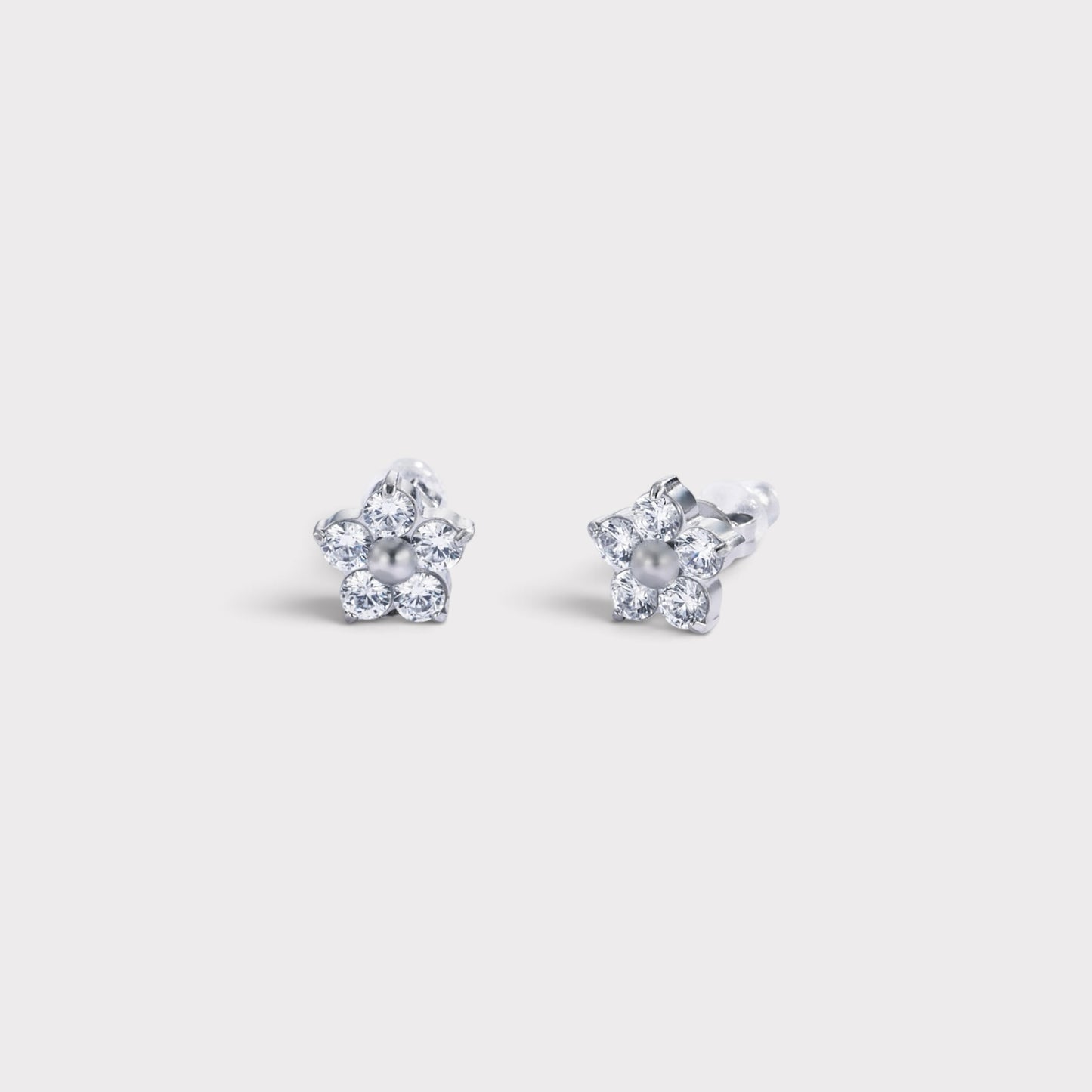 Brincos Verve em formato de flor com pérola central e pétalas cravejadas de zircónias brilhantes em metal prateado.