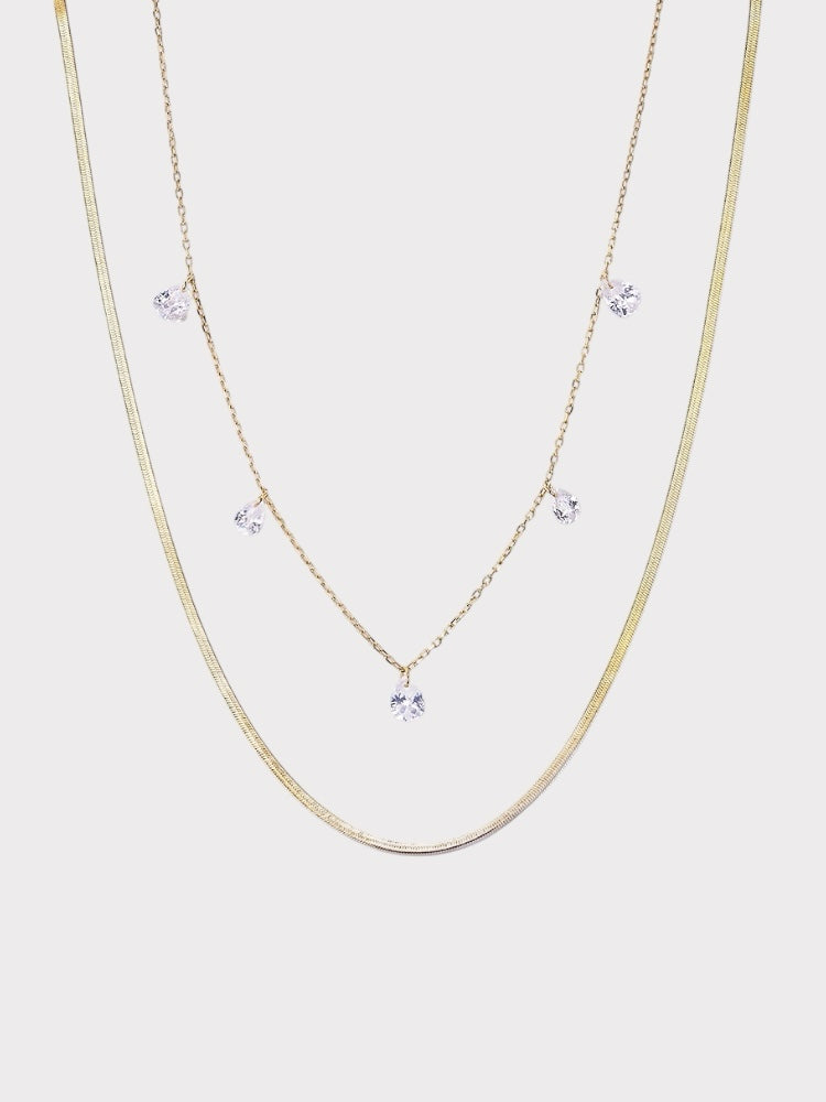 Colar duplo Verve em tom dourado com corrente snake e corrente fina com pontos de luz em zircônia.