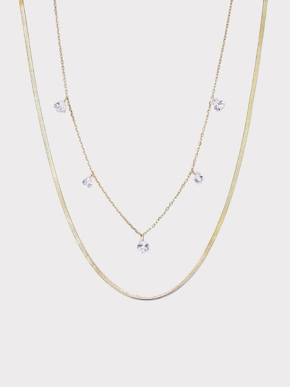 Colar duplo Verve em tom dourado com corrente snake e corrente fina com pontos de luz em zircônia.